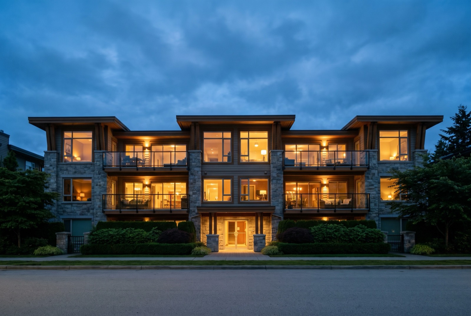A three-storey building at twilight with every window lit warm.